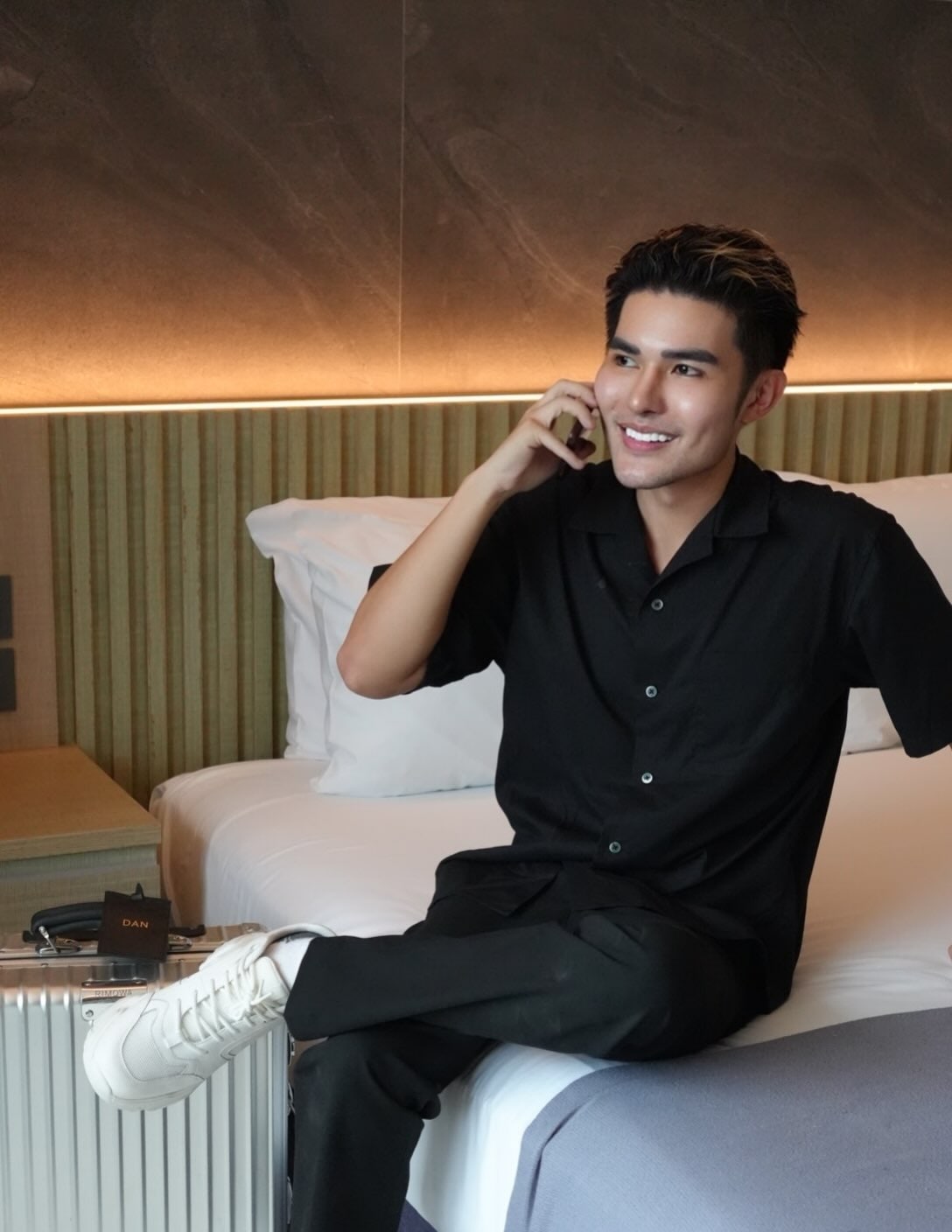 Danjo smiling while seated in a black outfit